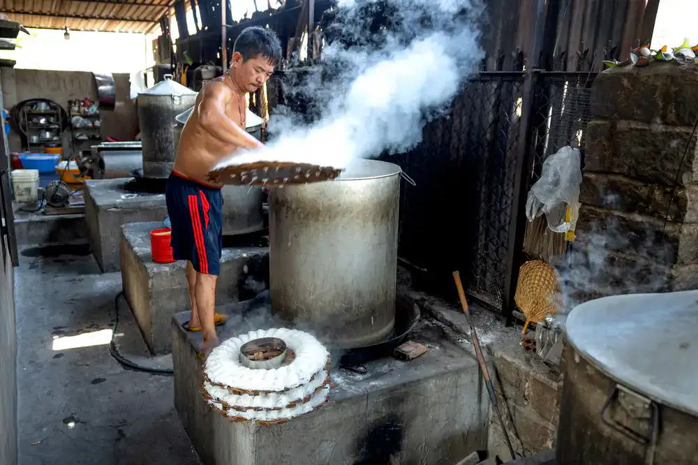 Steam rising from a large copper dye pot